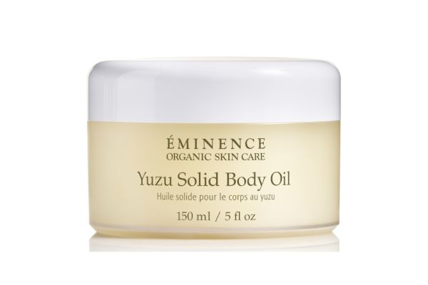 A jar of Éminence Organic Skin Care Yuzu Solid Body Oil, 150 ml / 5 fl oz, with white lid and yellow tinted container.